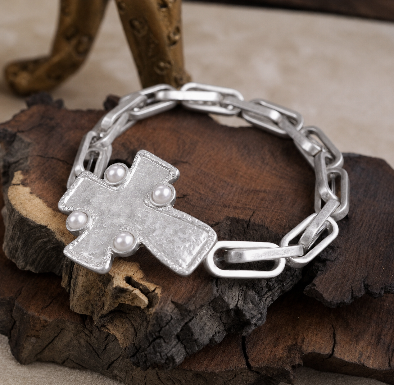 Silver cross pearl chain bracelet on rustic wood display