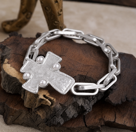 Silver cross pearl chain bracelet on rustic wood display