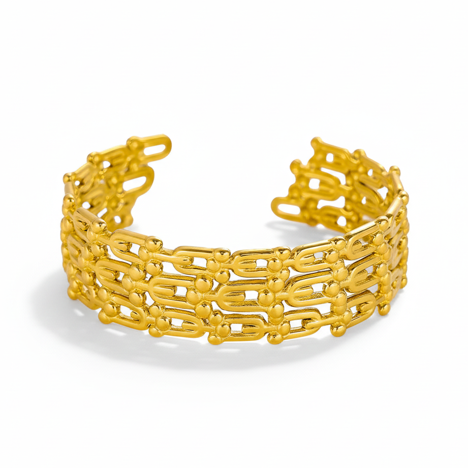 Gold chain-link cuff bracelet with matching ring on white background