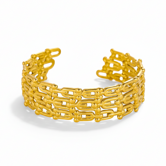 Gold chain-link cuff bracelet with matching ring on white background